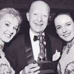 Russell Markert, the director of the Rockettes, proudly shows the award for "Best Dance Company in the Nation", in 1960.