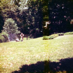 My dad in back, lawn mower, summer, 1977.